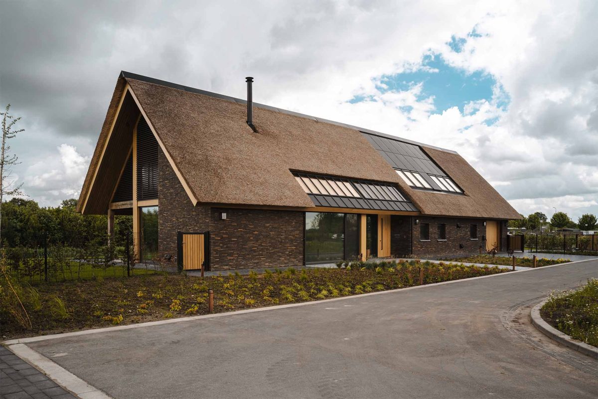 Modern landelijke villa met rieten kap en eeneikenhouten garagedeur