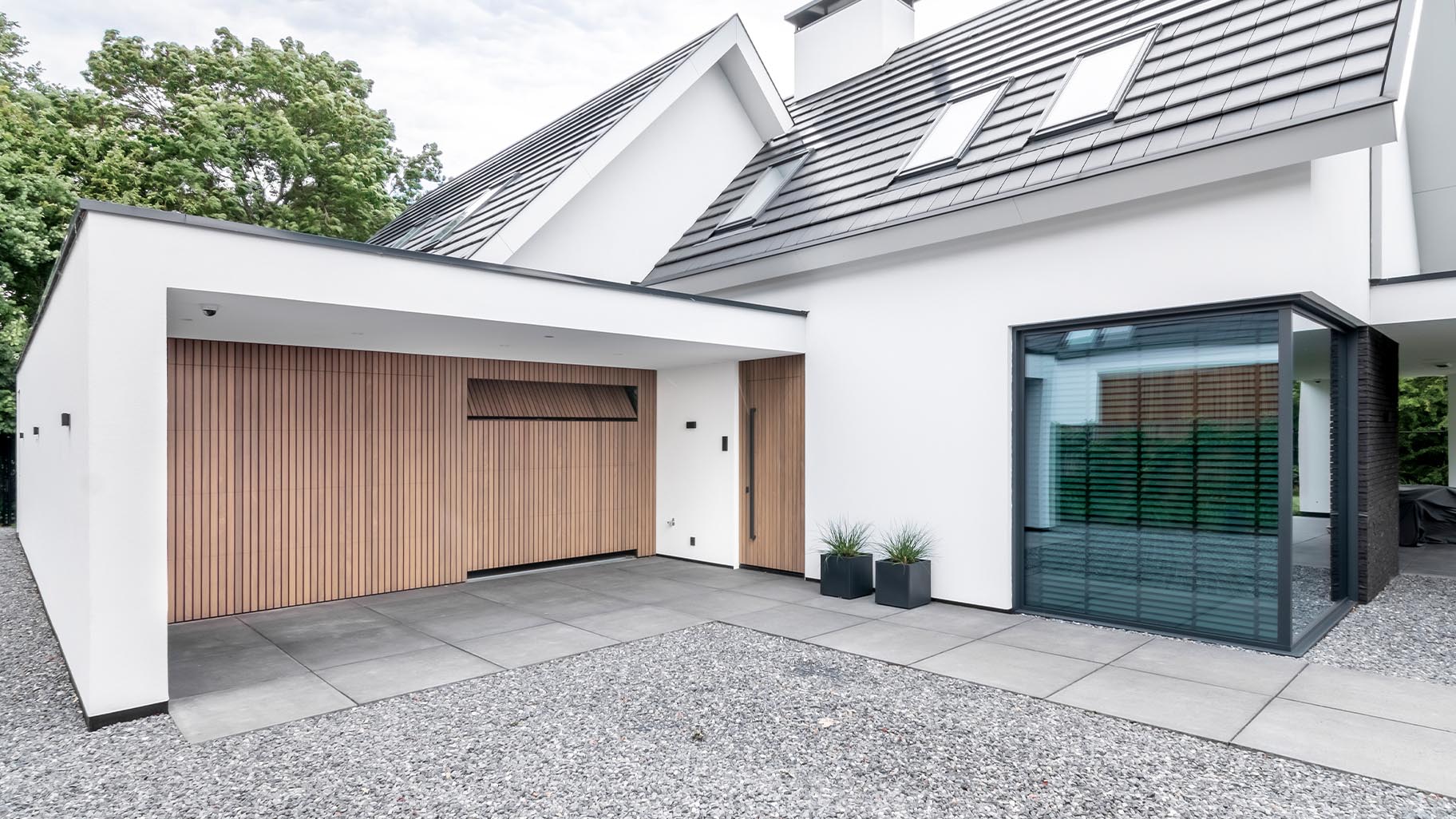 Moderne woning met Afrormosia houten garagedeuren en bijpassende voordeur die een luxe uitstraling geven aan het huis