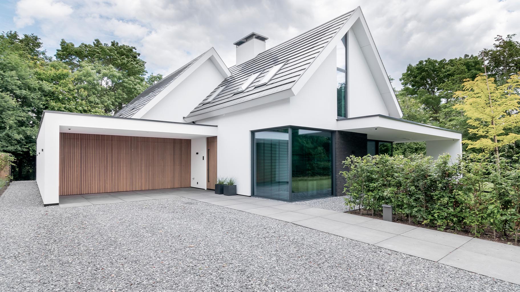 Moderne woning met Afrormosia houten garagedeuren en bijpassende voordeur die een luxe uitstraling geven aan het huis