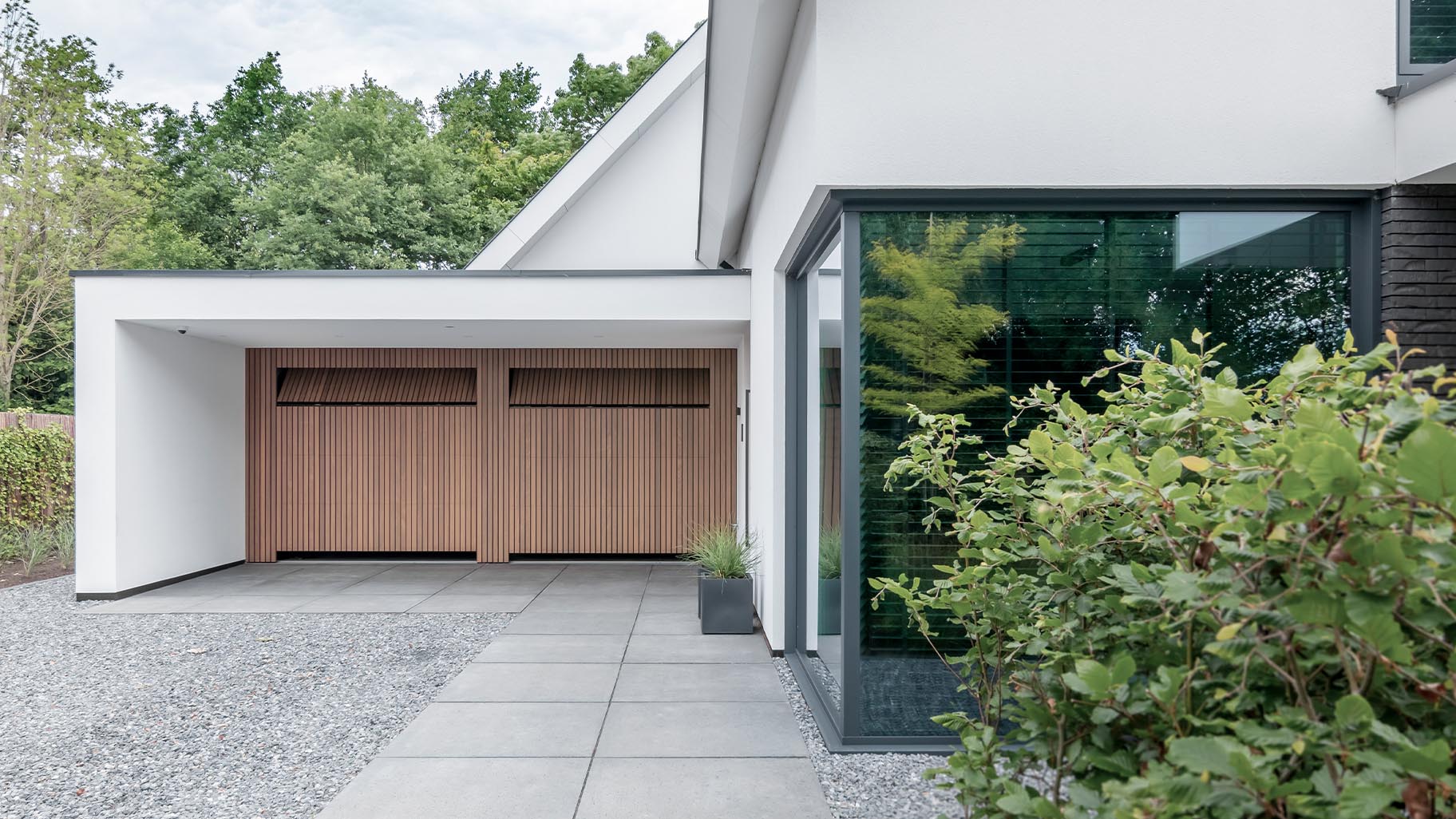 Op maat gemaakte Afrormosia houten garagedeuren en voordeur van Different Doors, ontworpen voor een stijlvolle woning