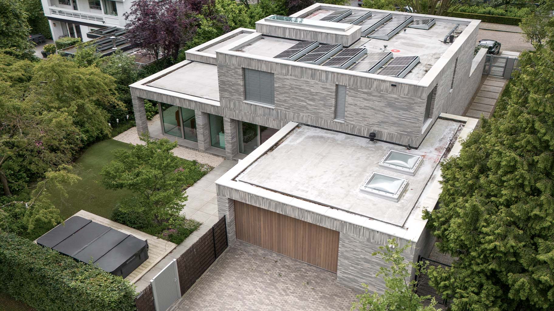 Dubbele zijwaartse garagedeuren van Different Doors, met een luxe uitstraling van Afrormosia hout, ontworpen voor deze moderne villa