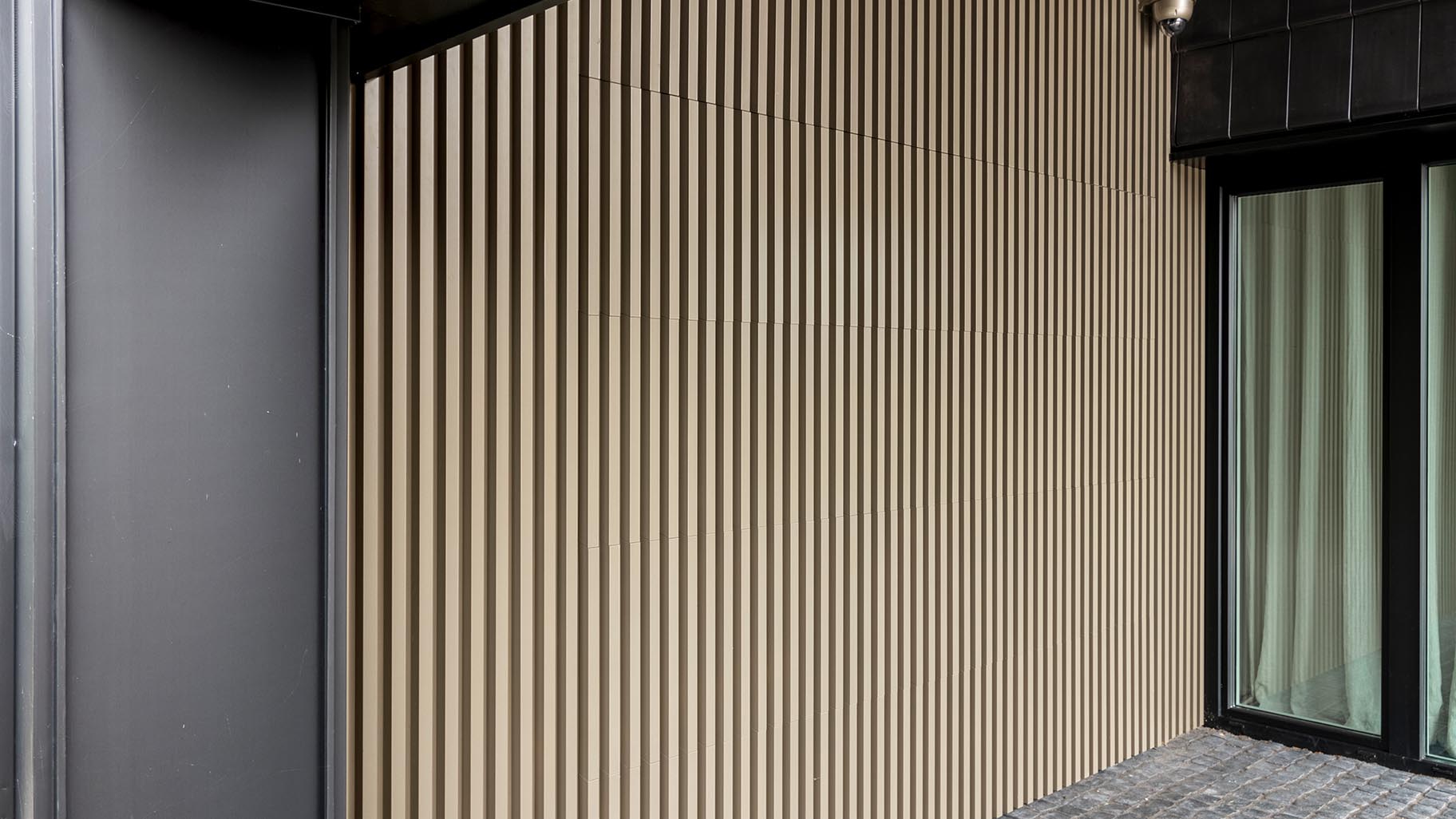 Detail van garagedeur met Mato 3 aluminium profielen, afgewerkt in de kleur Touch of Gold voor een luxe uitstraling