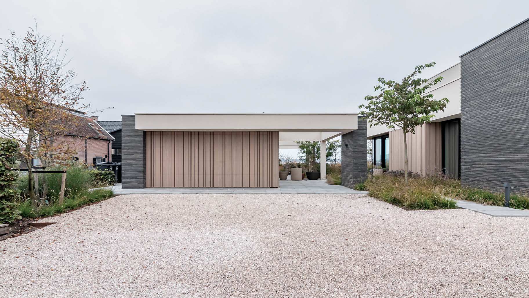 Strakke houten garagedeur onzichtbaar in de gevel