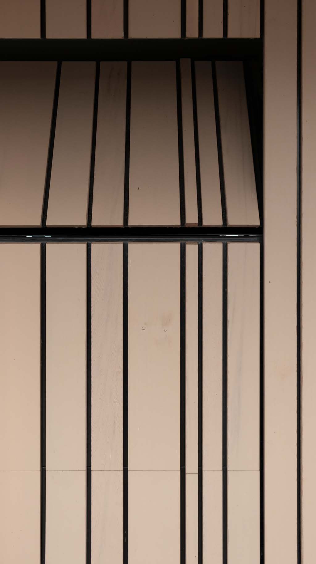 Houten garagedeur met verticale latten die gelijk met de gevel is geplaatst