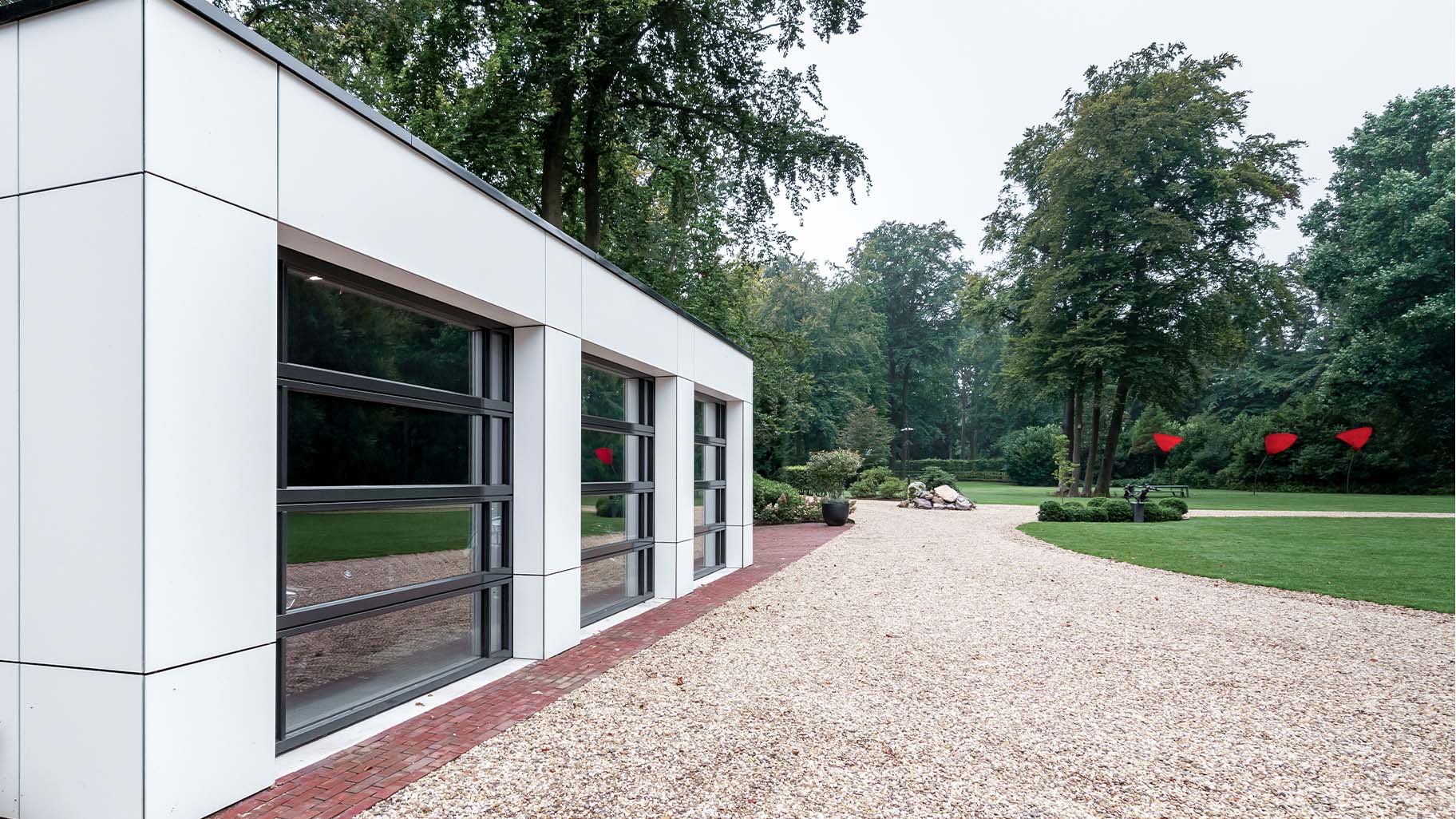 Garage met drie identieke glazen garagedeuren mooi in de gevel