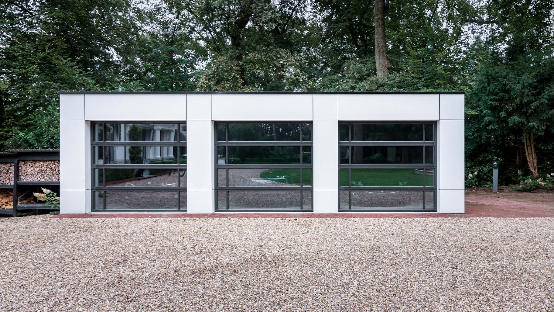 Garage met drie identieke glazen garagedeuren mooi in de gevel