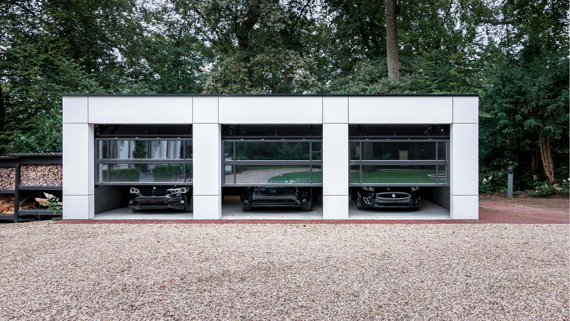 Garage met drie identieke glazen garagedeuren mooi in de gevel