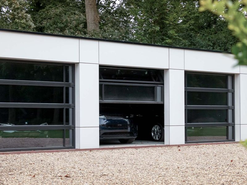 Garage met drie identieke glazen garagedeuren mooi in de gevel
