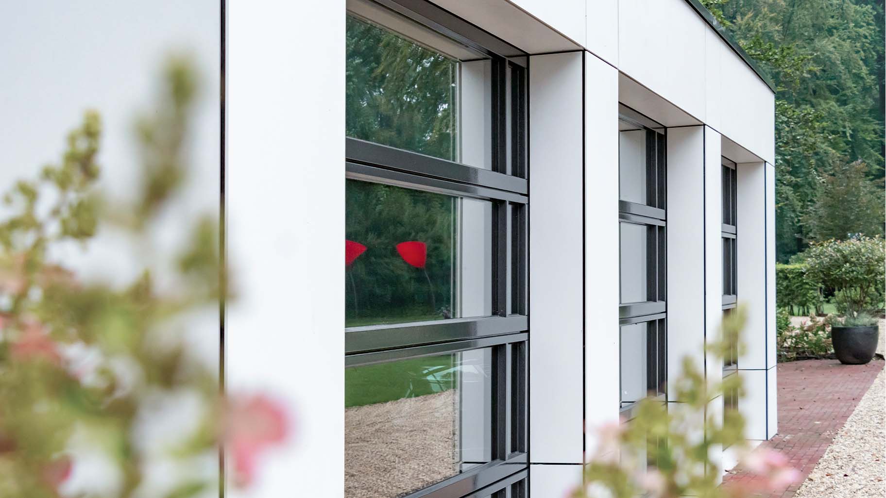 Garage bij landhuis met glazen gevel voor landelijk moderne uitstraling