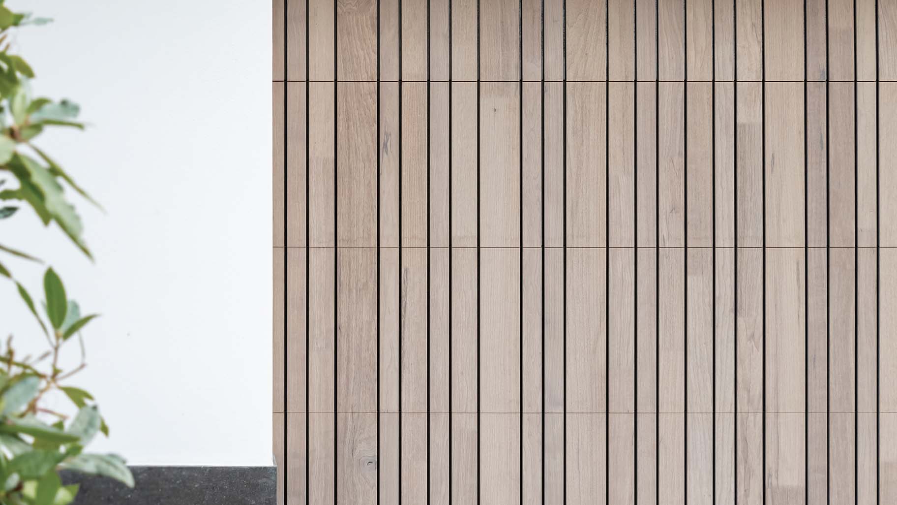 Close-up van fraké houten garagedeur met zichtbare houtnerf en warme tinten