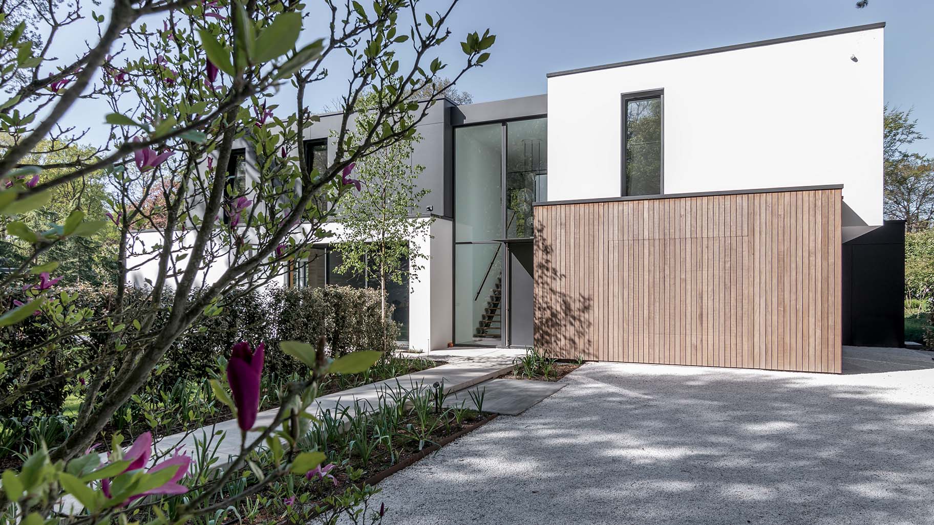 Different Doors garagedeur bij moderne villa in bosrijke omgeving