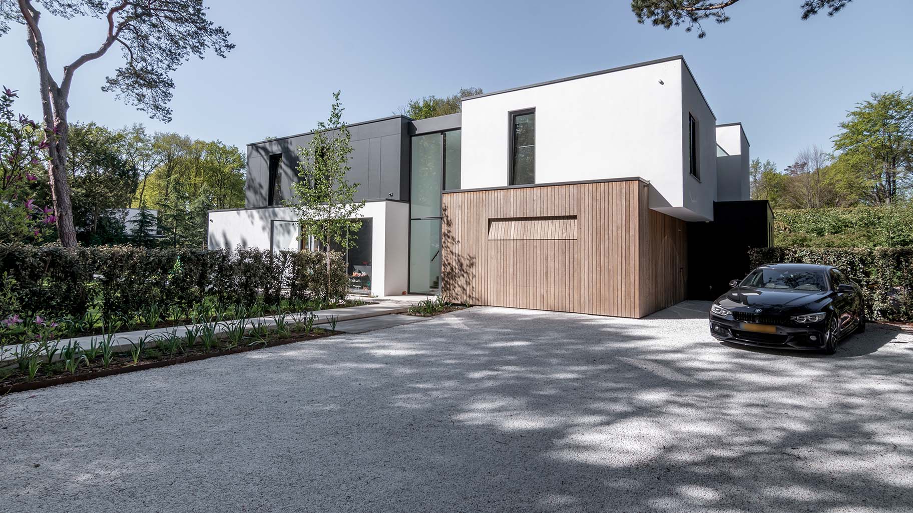 Different Doors garagedeur bij moderne villa in bosrijke omgeving