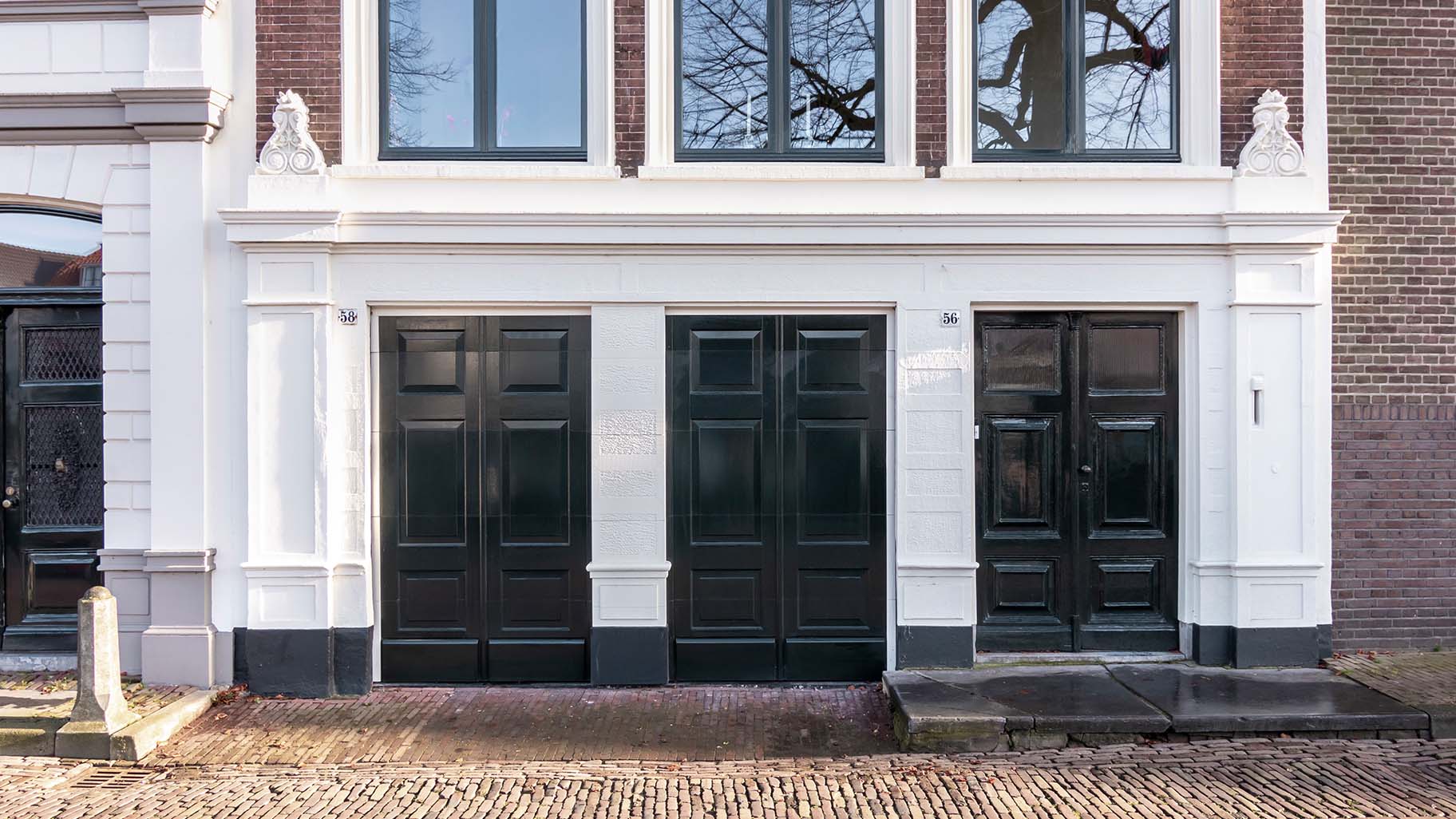 Onzichtbare houten garagedeur volledig geïntegreerd in de gevel van monumentaal pand in Gorinchem