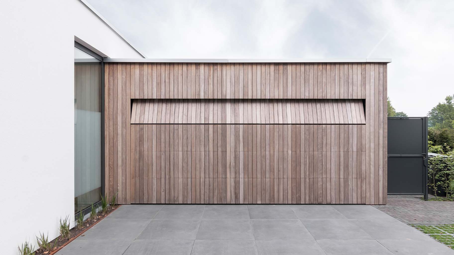 Luxe houten garagedeur die gelijk met de gevel is geplaatst