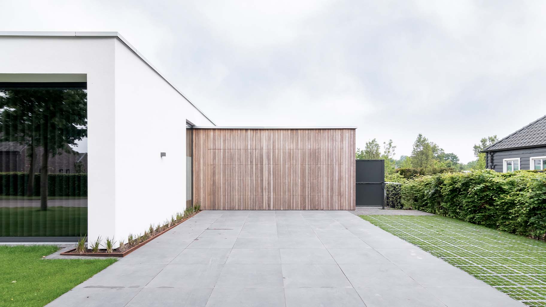 Luxe houten garagedeur die gelijk met de gevel is geplaatst