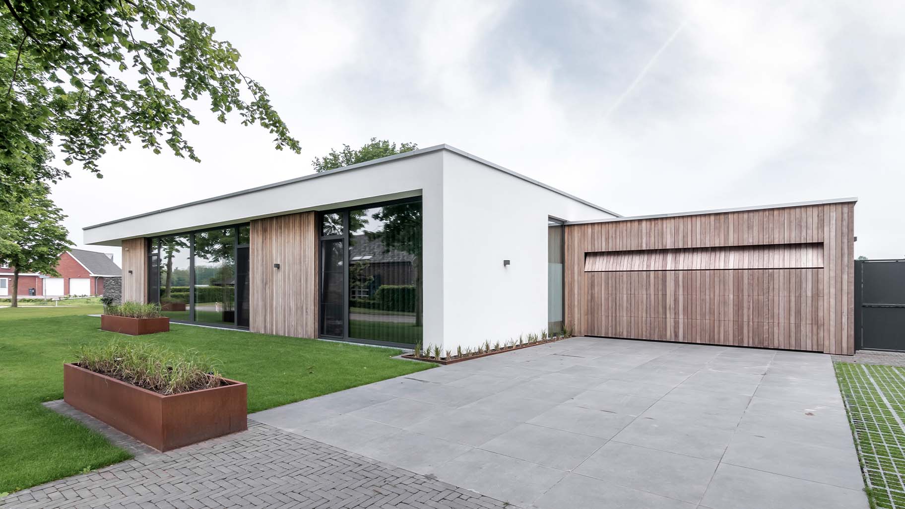 Strakke wit gestucte villa met houten garagedeur