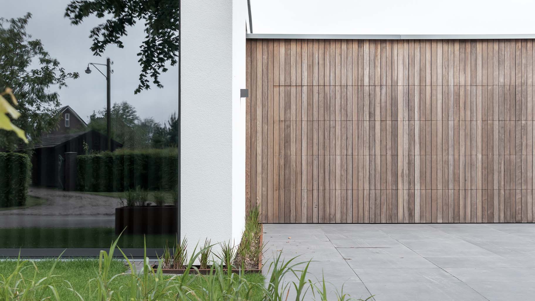 Luxe houten garagedeur die gelijk met de gevel is geplaatst