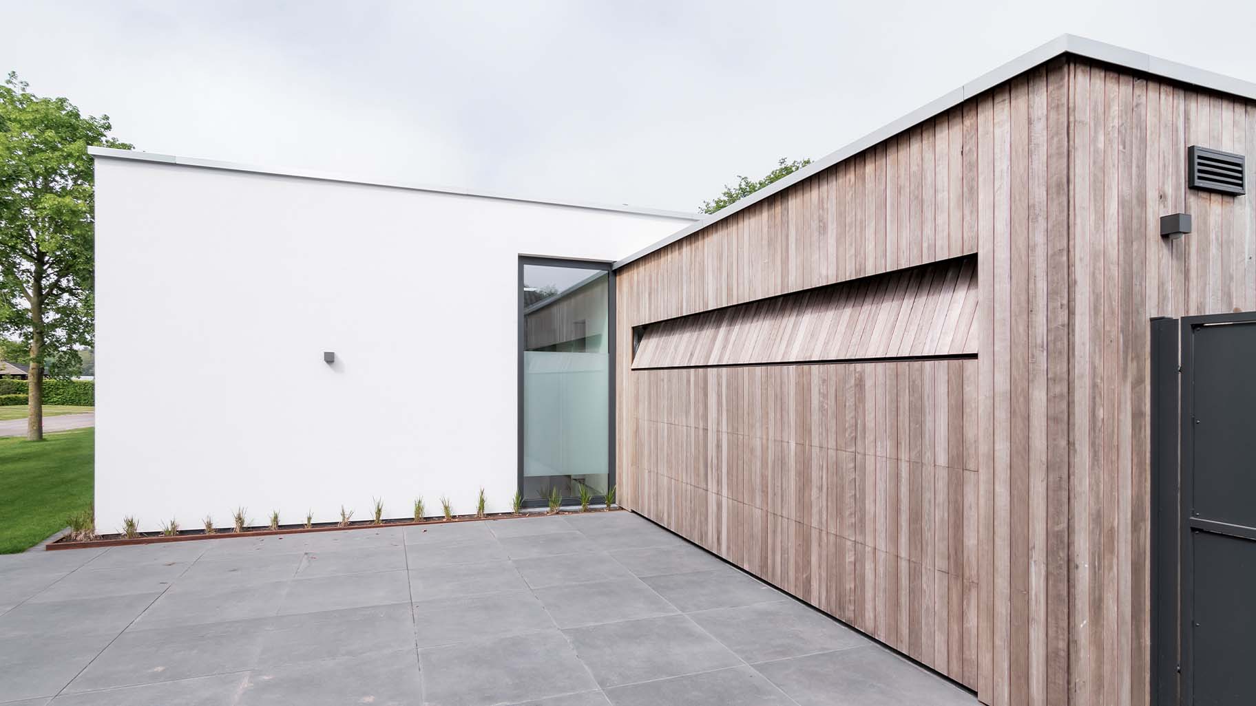 Strakke wit gestucte villa met houten garagedeur