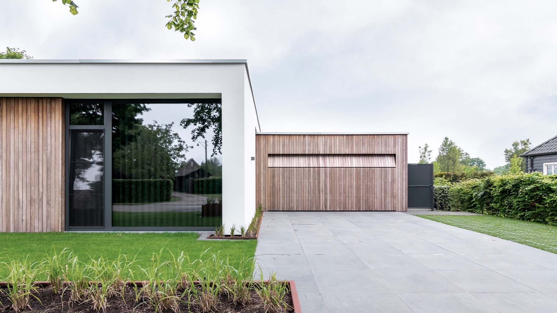 Strakke wit gestucte villa met houten garagedeur