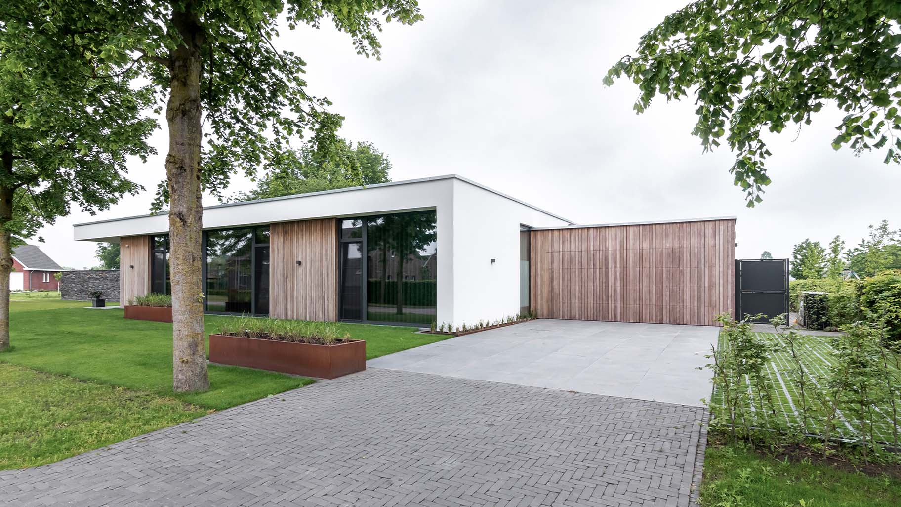 Strakke wit gestucte villa met houten garagedeur