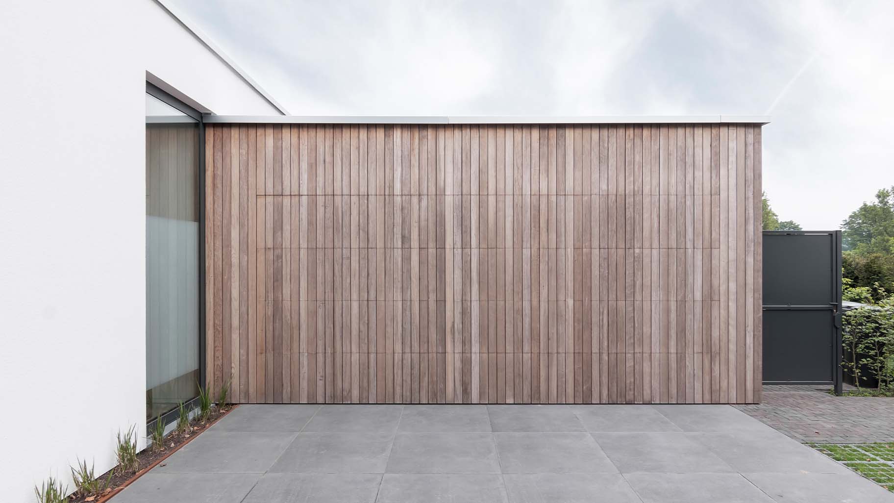 Luxe houten garagedeur die gelijk met de gevel is geplaatst