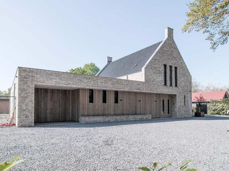 Onzichtbare houten garagedeur geïntegreerd in de gevel, gerealiseerd door Different Doors