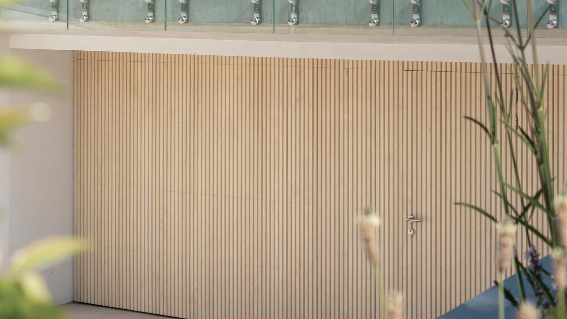 Garage met op maat gemaakte Accoya houten sectionaaldeuren en geïntegreerde loopdeu