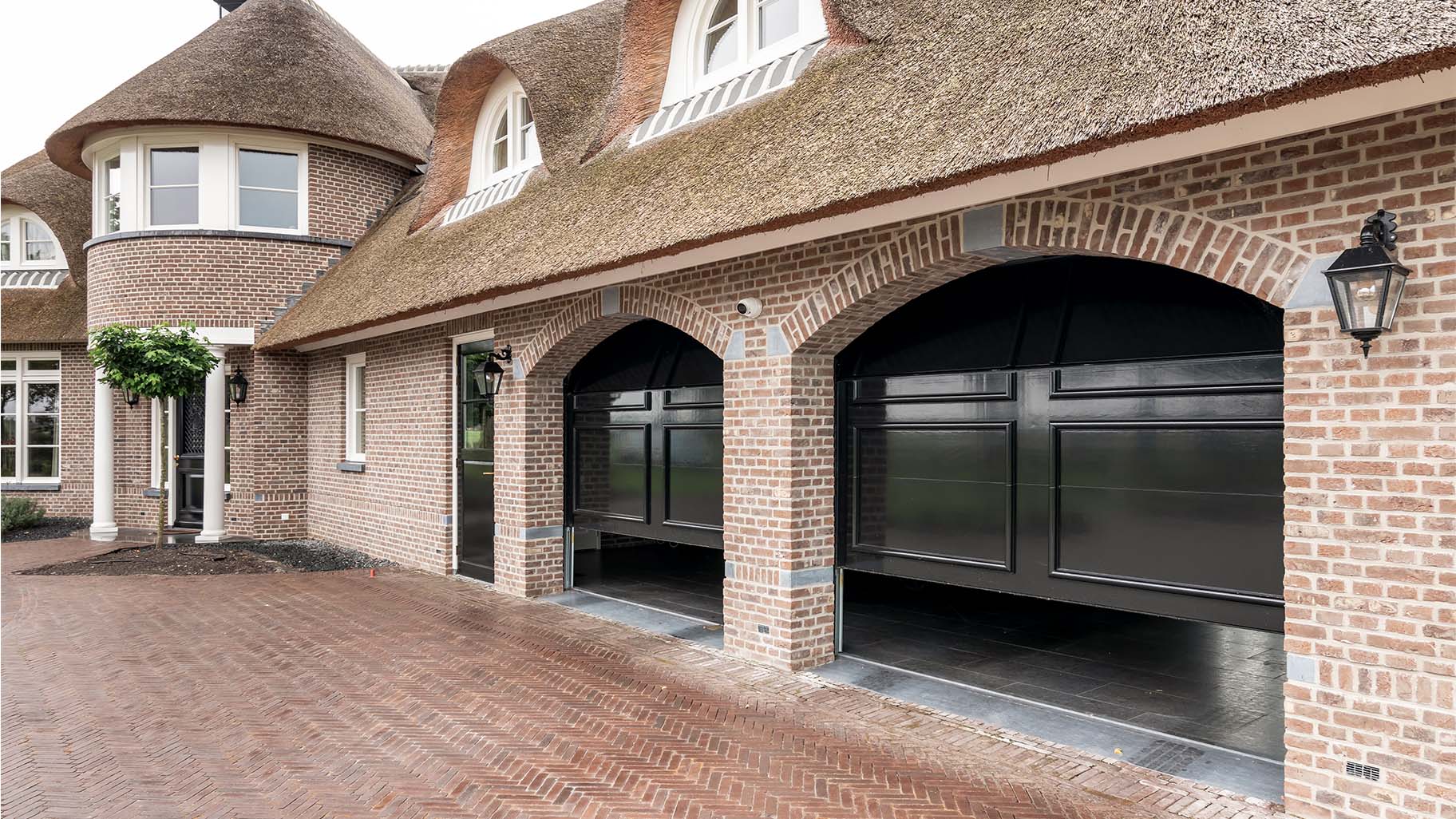 Landelijke woning met twee houten garagedeuren in klassieke stijl
