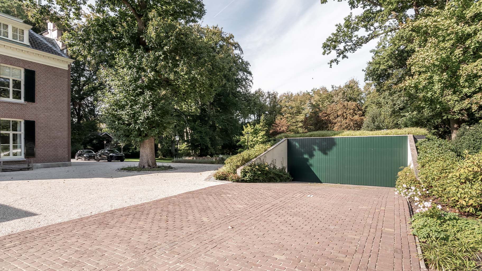 Unieke garage met twee houten sectionaaldeuren in diepgroene kleur