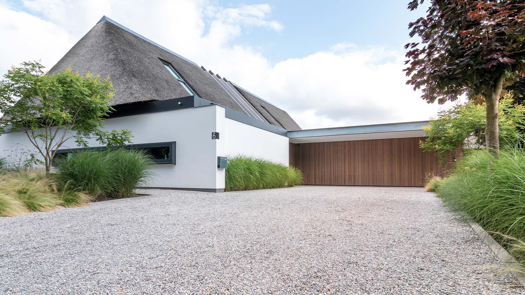 Moderne woning met houten garagedeur 5 meter breed gelijk met de wand