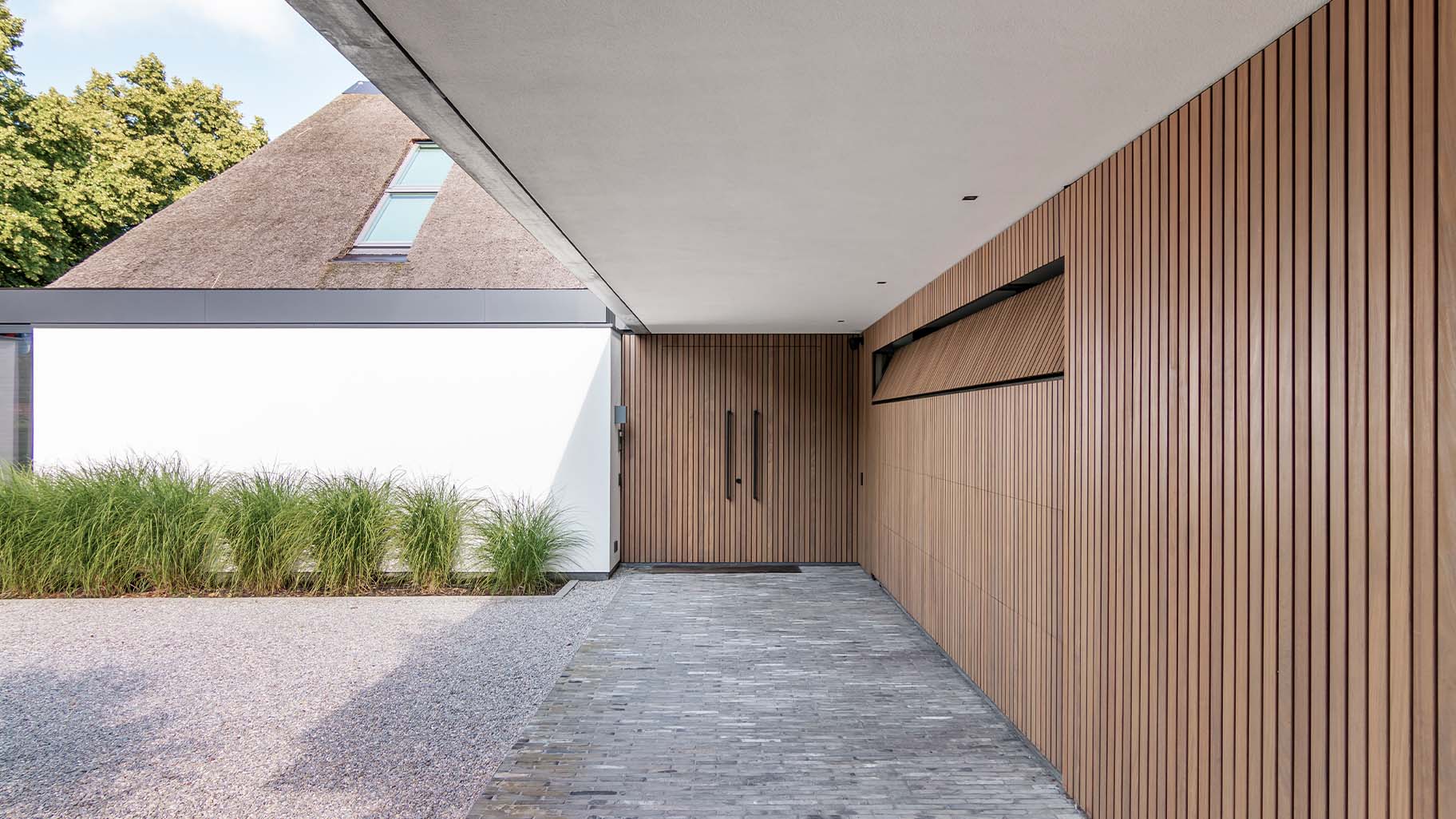 Afrormosia houten gevel met garagedeur en voordeur