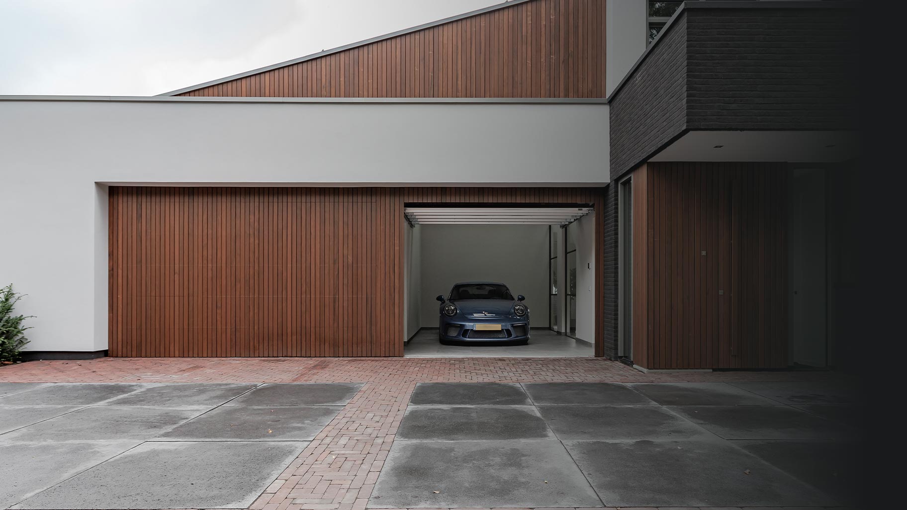 2 houten garagedeuren gelijk met de gevel
