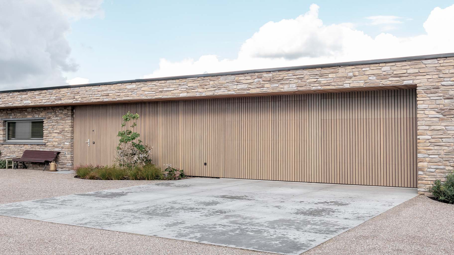 Moderne nieuwbouwwoning met twee houten sectionaaldeuren van Afrormosia hout