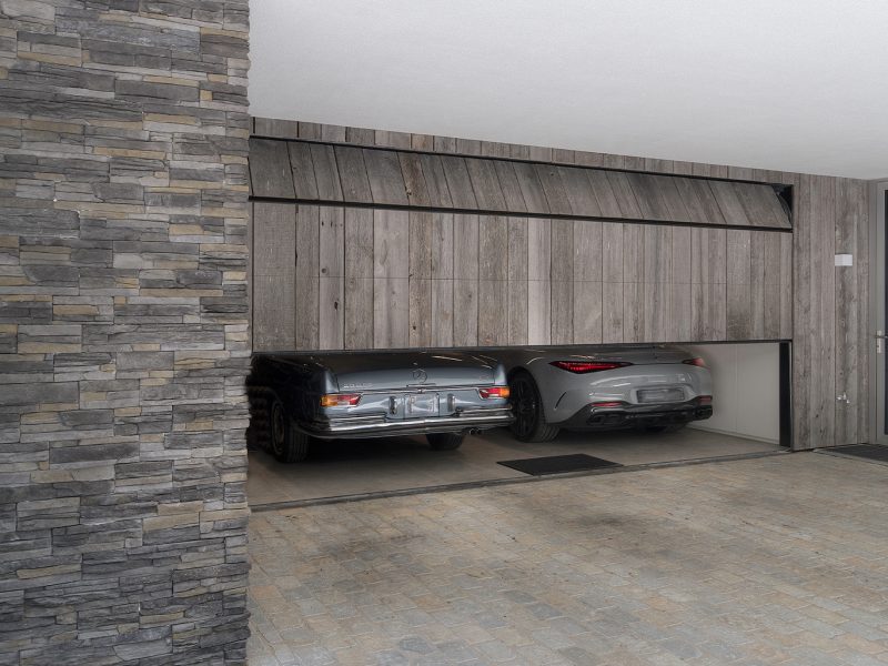 Garagedeur in moderne villa van duurzaam en gerecycled Barnwood, net zoals de gevelbekleding