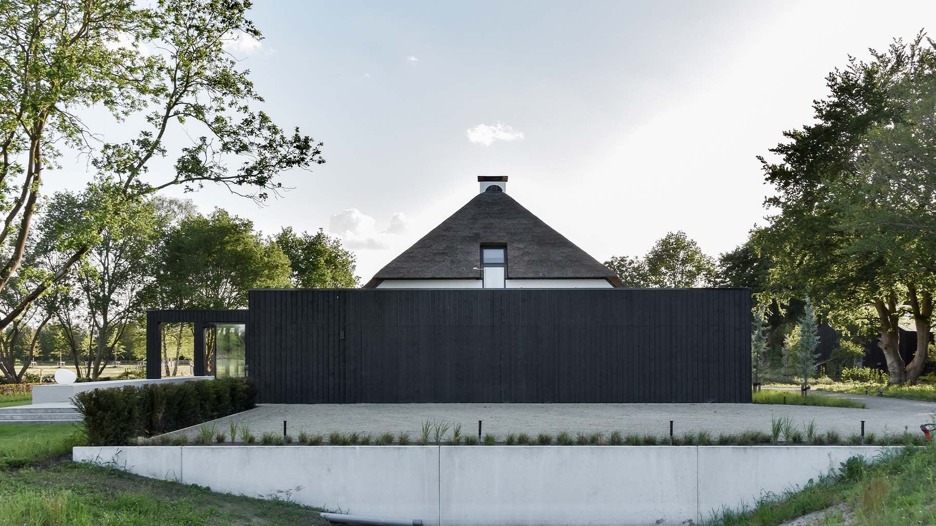 Dubbele houten garagedeur door Different doors gemaakt in de gevel