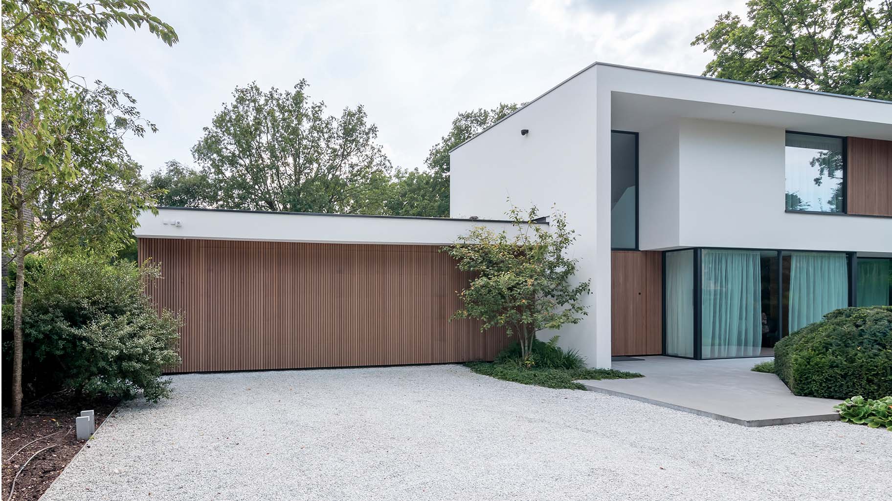 Red Cedar houtachtige garagedeur met zelfde gevelbekleding als het exterieur van de woning