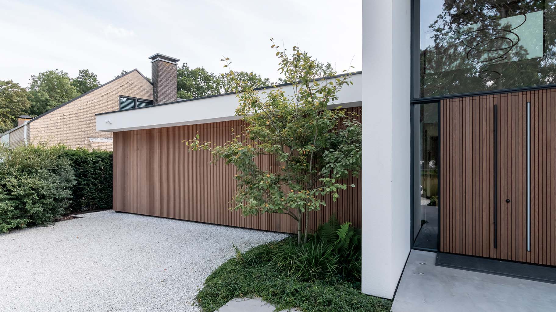 Red Cedar houtachtige garagedeur met zelfde gevelbekleding als het exterieur van de woning