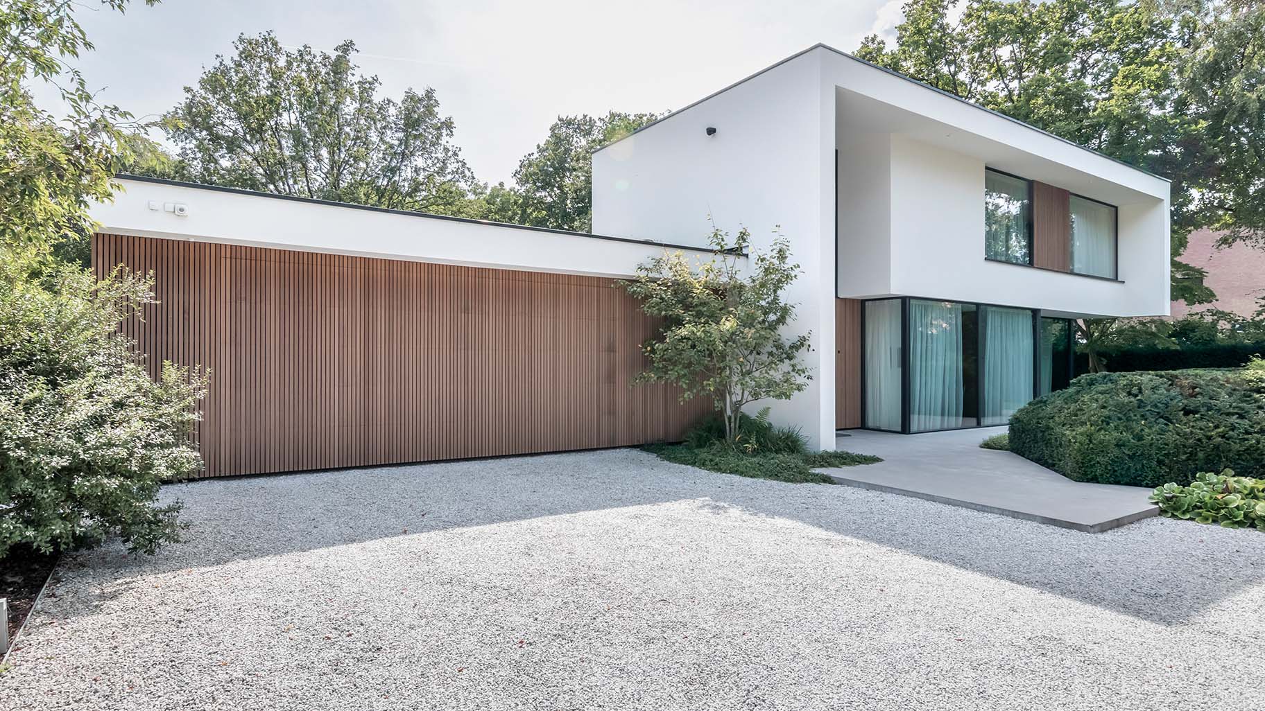 Red Cedar houtachtige garagedeur met zelfde gevelbekleding als het exterieur van de woning