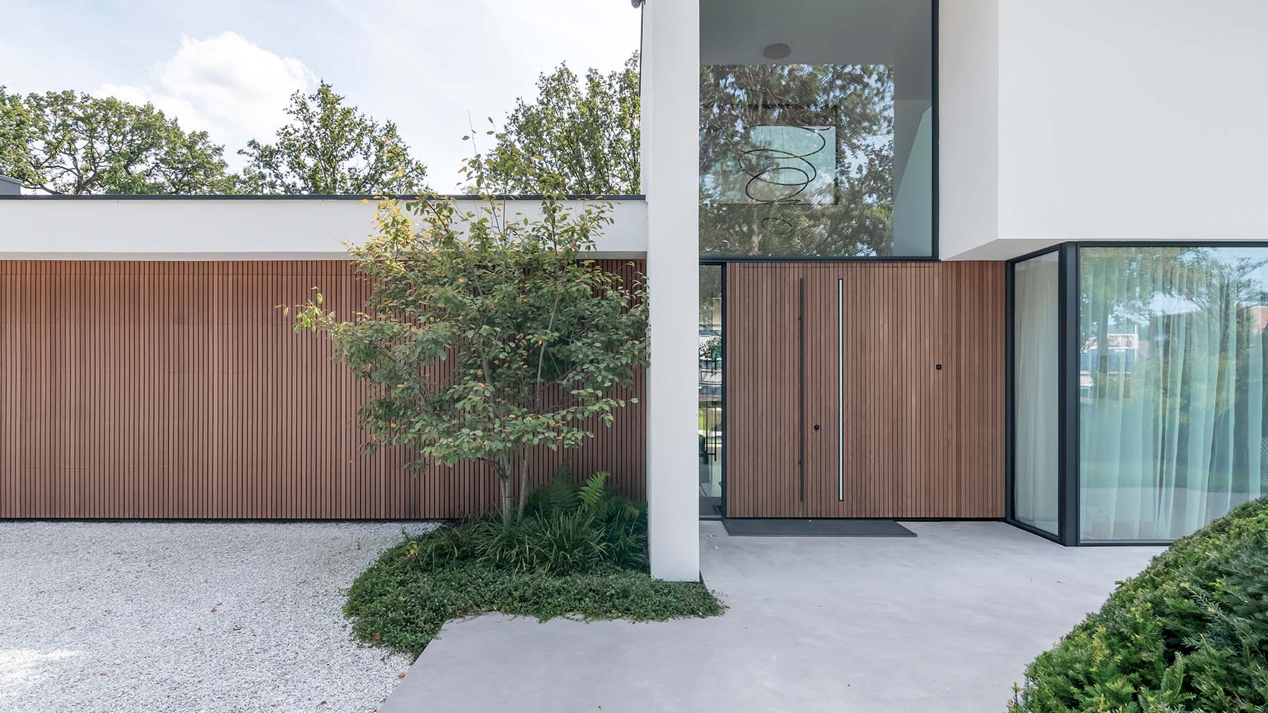 Red Cedar houtachtige garagedeur met zelfde gevelbekleding als het exterieur van de woning