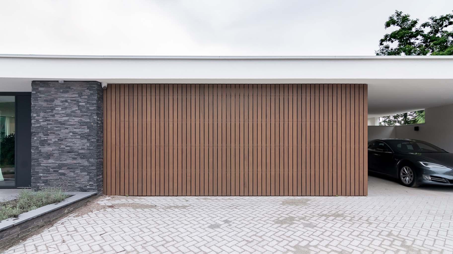 Houten sectionaaldeur bij bijzondere bungalow gemaakt door Different Doors