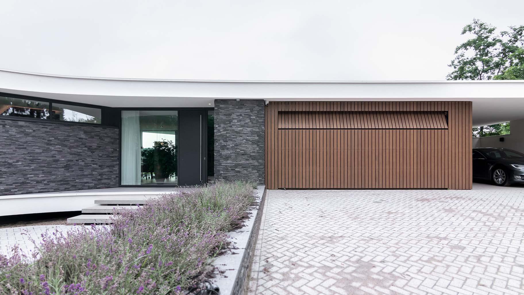 Houten sectionaaldeur bij bijzondere bungalow gemaakt door Different Doors