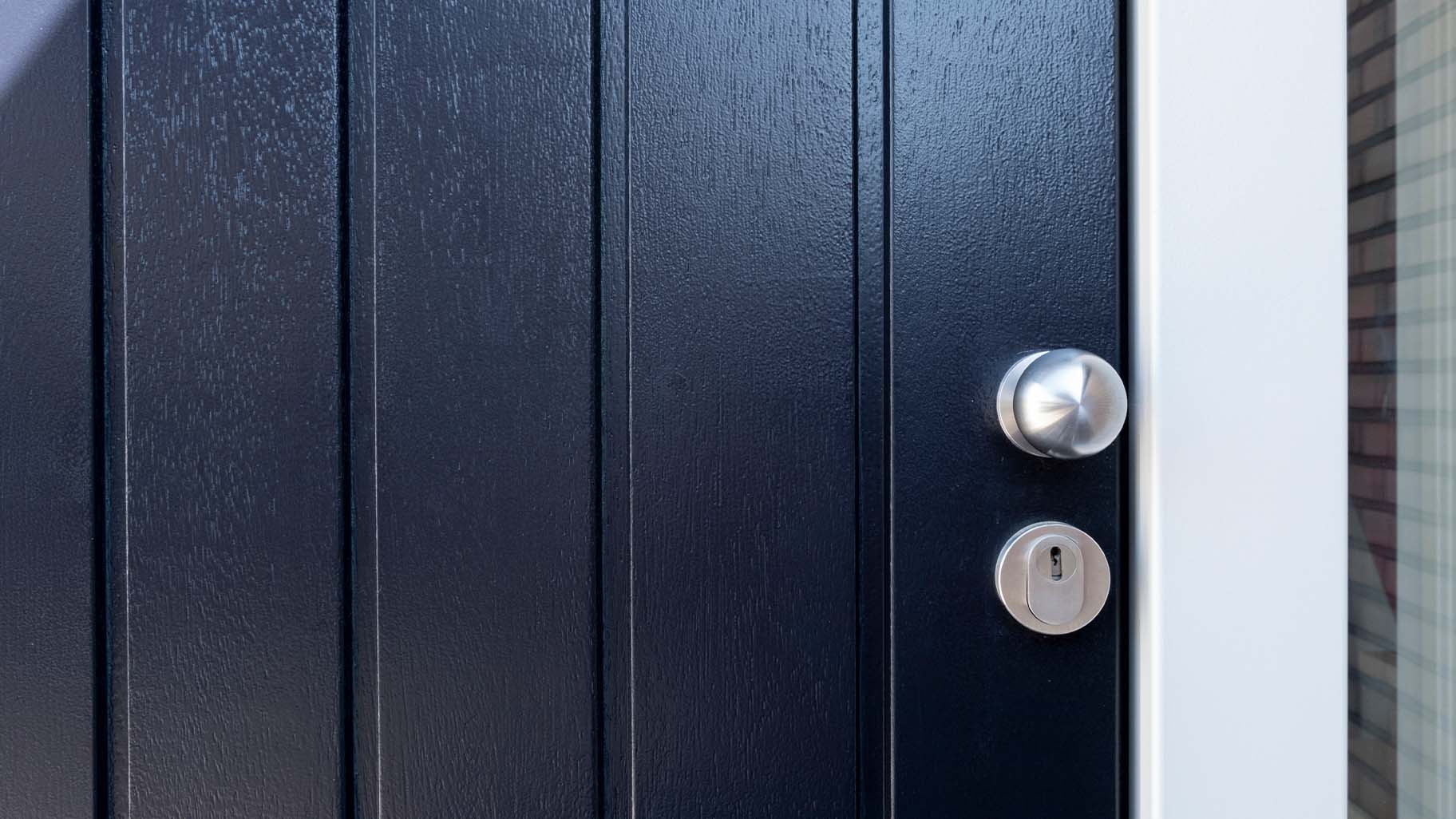 Houten verticale garagedeur en voordeur