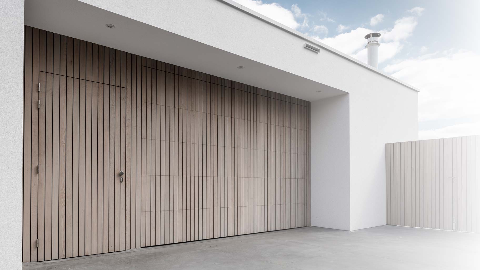 Verticale garagedeur en loopdeur in 1 vlak met de wand Red Cedar latten different doors