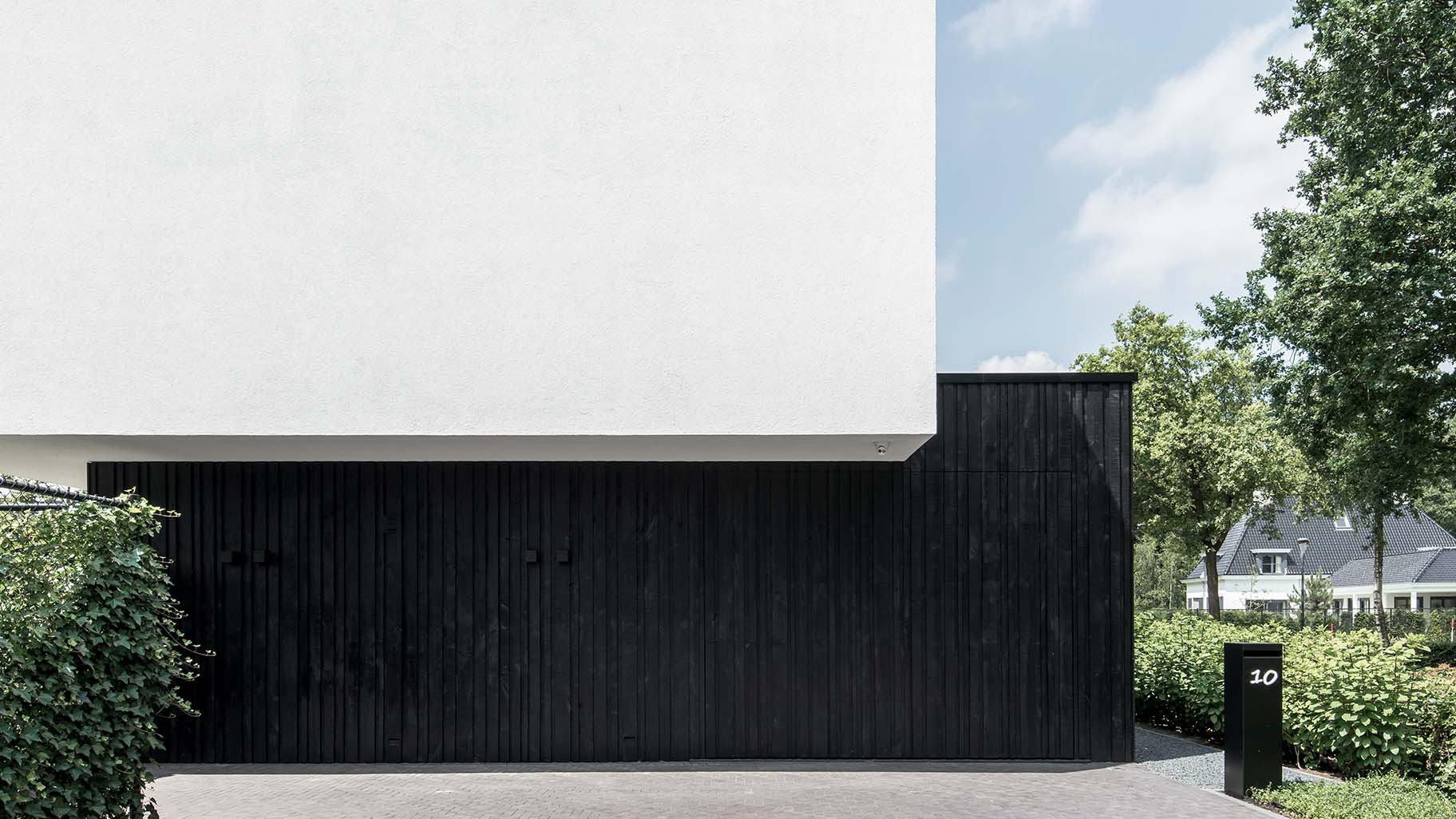 Verticale houten latten in het zwart verwerkt in elektrische garagedeur