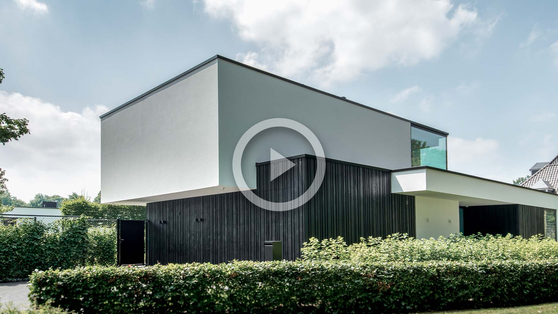 Moderne zwarte garagedeur met verticale houten latten in diverse breedtes, contrasterend met witte gevel video