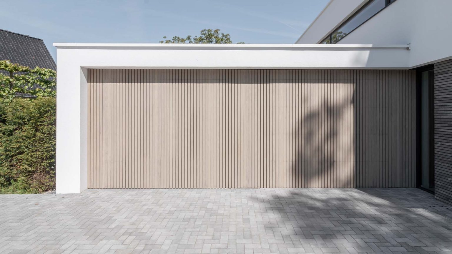 Verticale frake hout garagedeur gelijk met de gevel | Different Doors