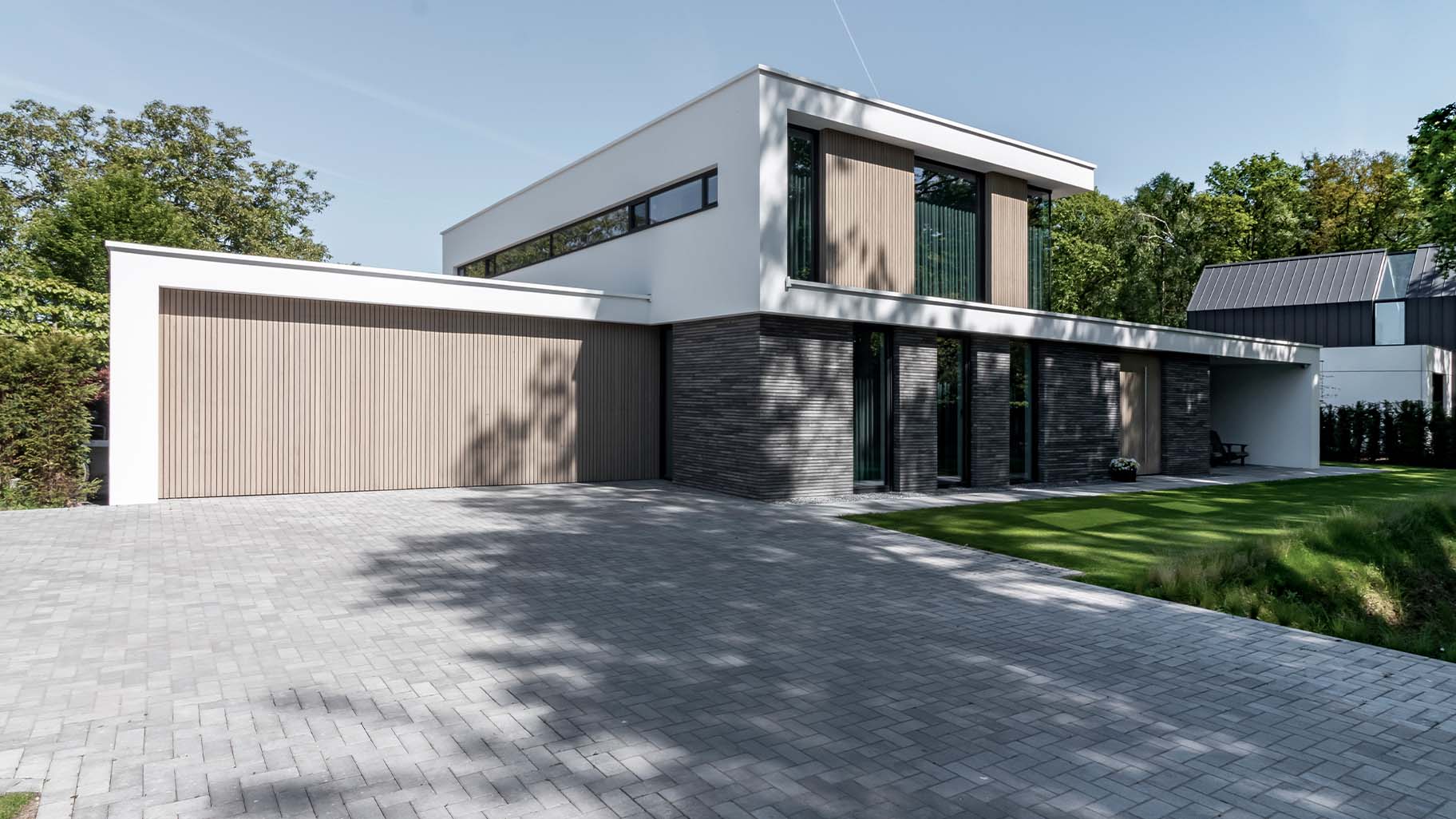 Moderne villa met twee frake houten garagedeuren die naar boven openen