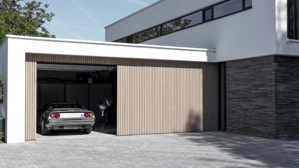 Verticale frake hout garagedeur gelijk met de gevel | Different Doors