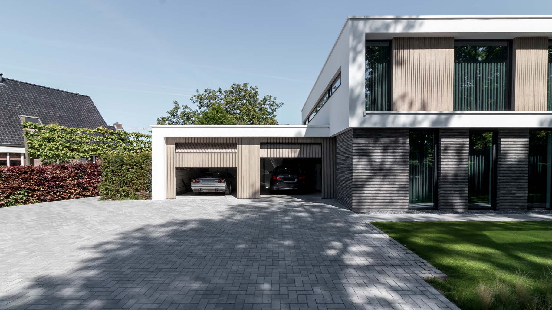 Moderne villa met twee frake houten garagedeuren die naar boven openen