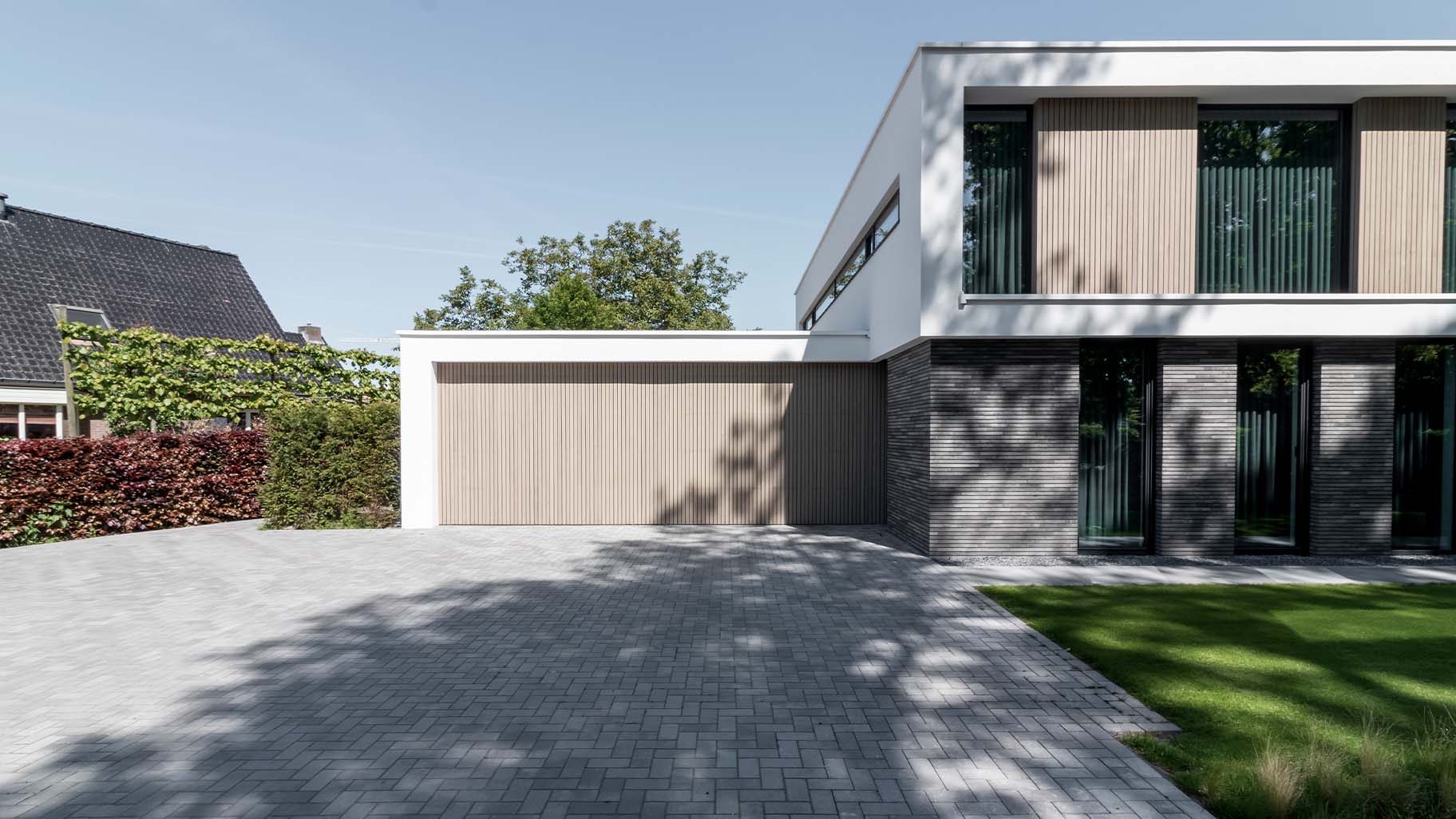 Moderne villa met twee frake houten garagedeuren in de garage